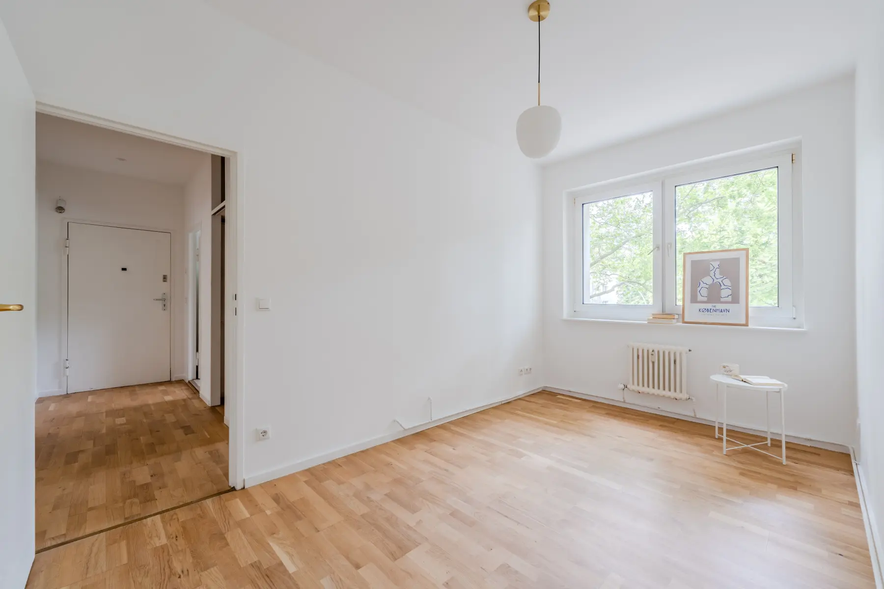 Heller Wohnbereich mit großem Fenster und Parkett