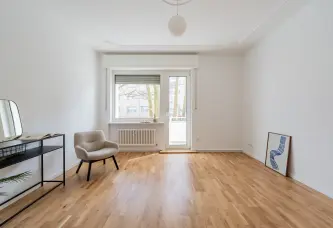 Wohnzimmer mit Balkontür und Parkett